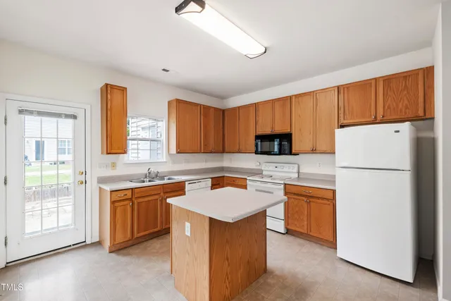 a kitchen with stainless steel appliances granite countertop a sink stove refrigerator and cabinets