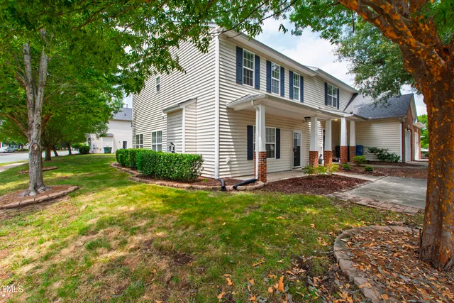 a front view of a house with a yard and trees