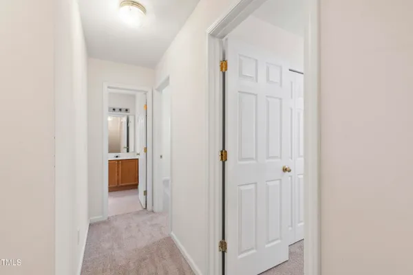 a view of a hallway with closet and a bathroom