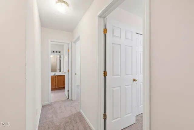 a view of a hallway with closet and a bathroom