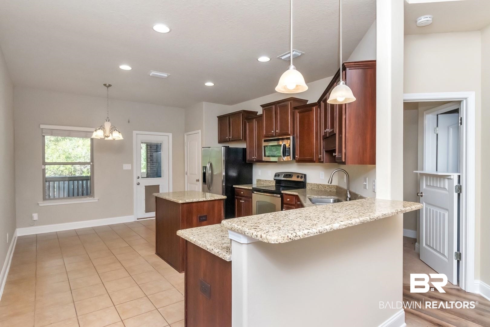 6144 Whitebark Drive Mobile, AL 36693 - Photo 7 of 33 Kitchen featuring stainless steel appliances, sink, pendant lighting, a chandelier, and a center island