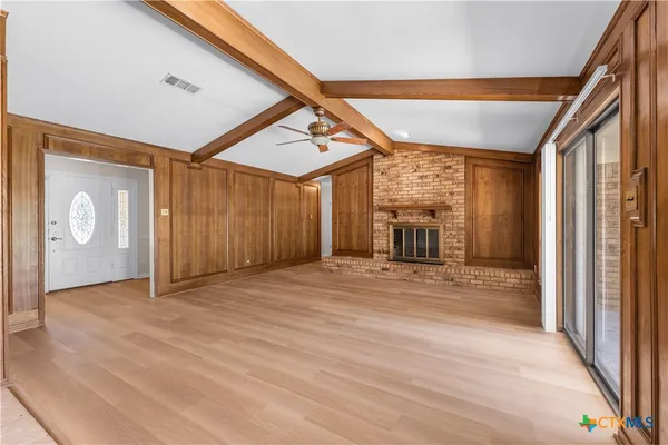 a view of a livingroom with wooden floor and a ceiling fan