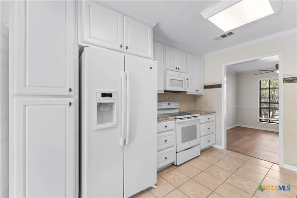 a kitchen with stainless steel appliances white cabinets and a refrigerator
