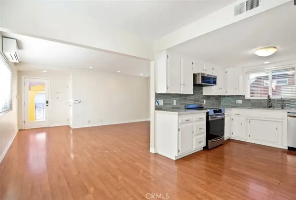 a kitchen with granite countertop a stove a sink and a microwave