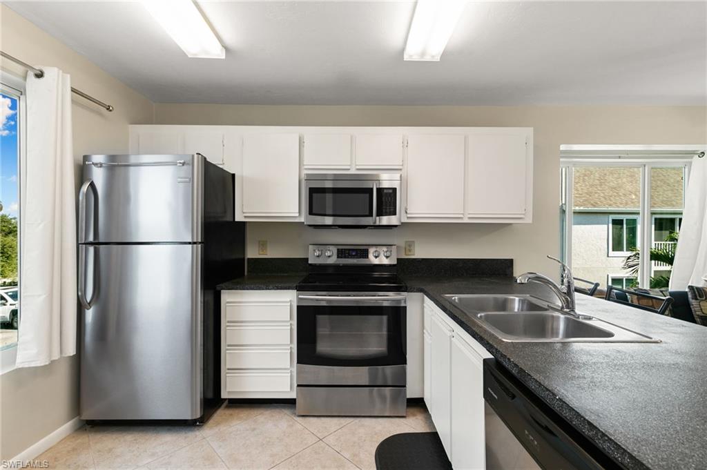 2149 San Marco Road, Unit 201 Marco Island, FL 34145 - Photo 8 of 22 a kitchen with a sink and a refrigerator