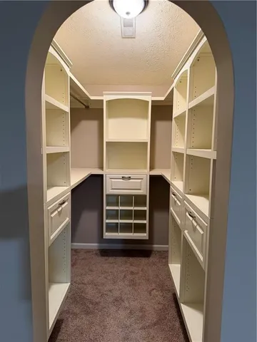 a view of an empty room with a cabinet and a window