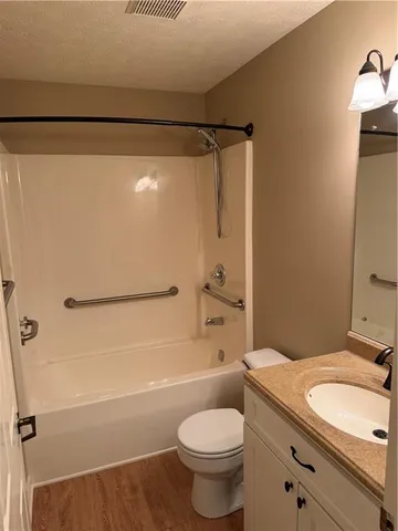 a bathroom with a granite countertop sink toilet and shower