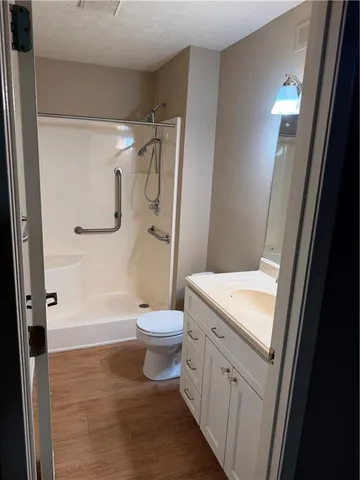 a bathroom with a sink a toilet and shower