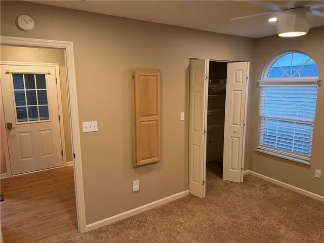 an empty room with windows and closet