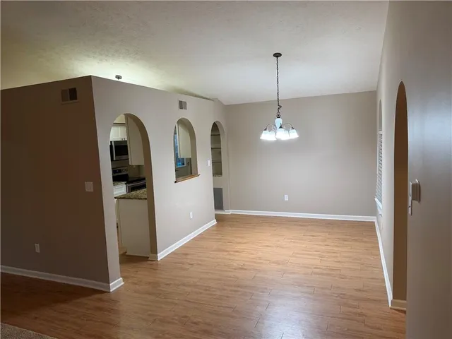 a view of a hallway with wooden floor and stairs
