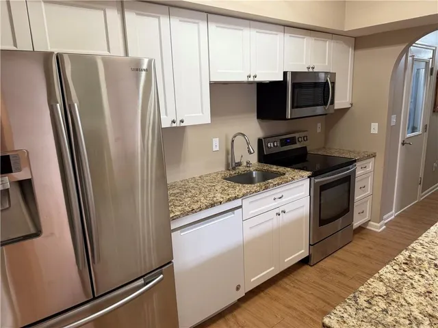 a kitchen with stainless steel appliances a refrigerator sink and microwave