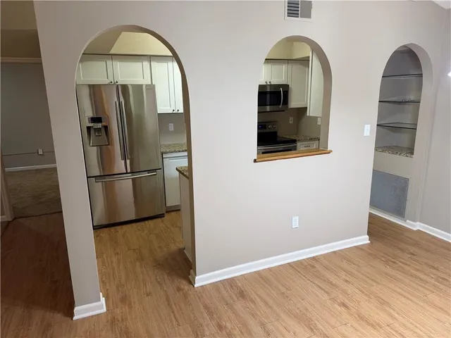a view of kitchen with wooden floor electronic appliances and wooden floor