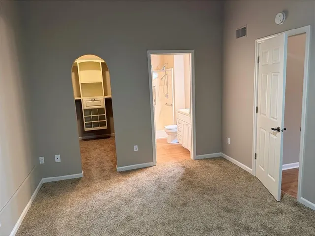 an empty room with windows mirror and balcony
