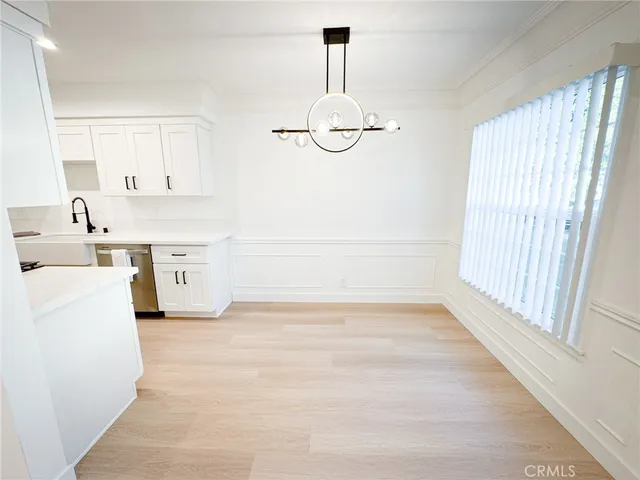 a view of kitchen with a sink wooden floor and windows