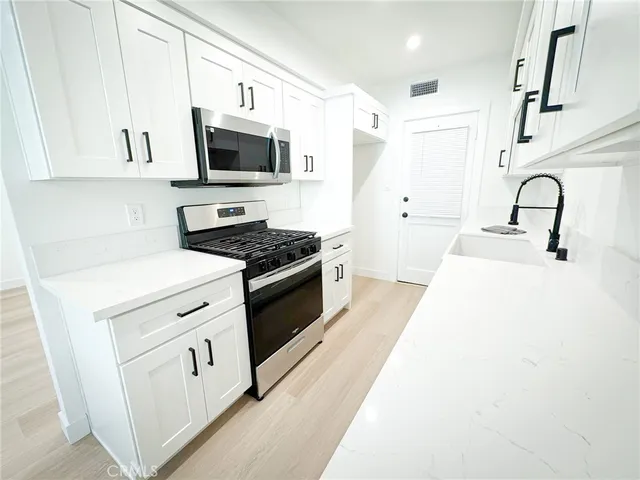 a kitchen with stainless steel appliances a white stove top oven and a refrigerator