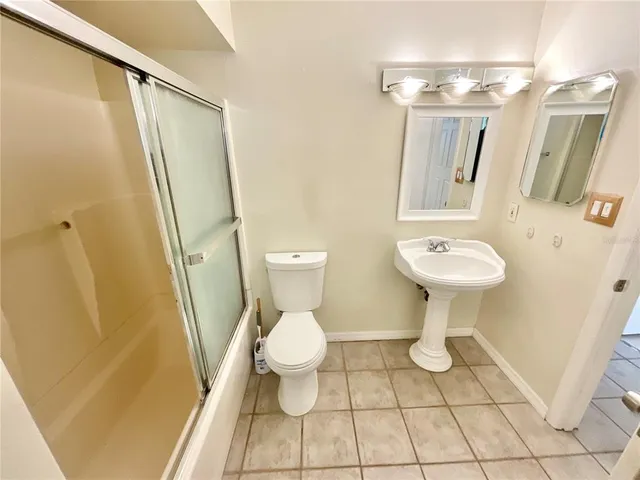 a bathroom with a sink toilet a mirror and shower