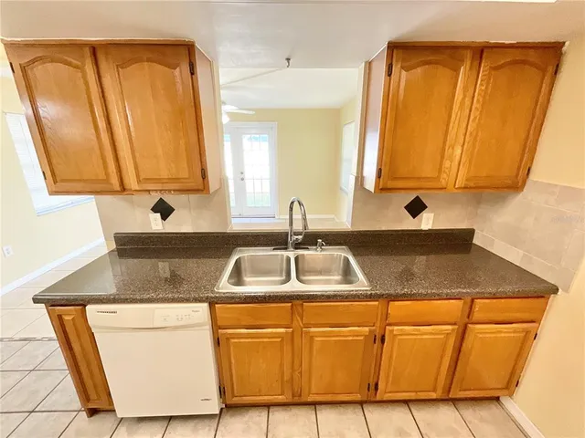 a kitchen with stainless steel appliances granite countertop a sink and a refrigerator