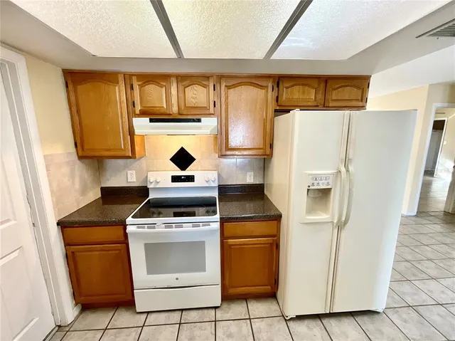 a kitchen with a stove top oven cabinets and refrigerator