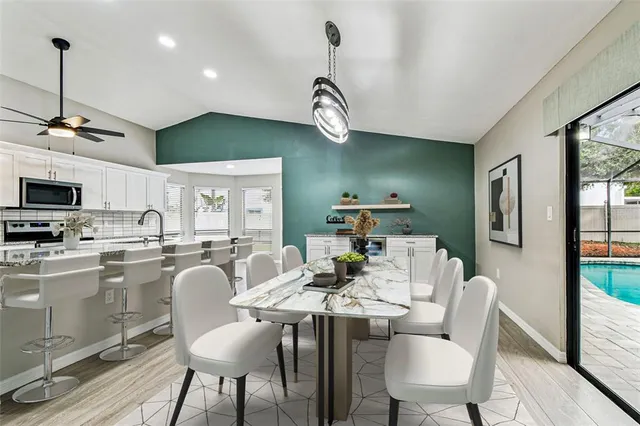 a view of a kitchen center island wooden floor and stainless steel appliances