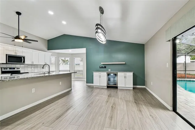 a view of a kitchen with stainless steel appliances granite countertop a sink a stove a refrigerator counter top space and cabinets