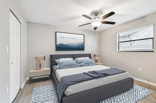 a view of a livingroom with a chandelier fan and windows