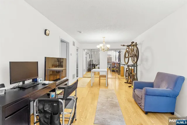 a view of a livingroom with workspace and a flat screen tv