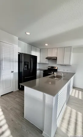 a kitchen with refrigerator and cabinets