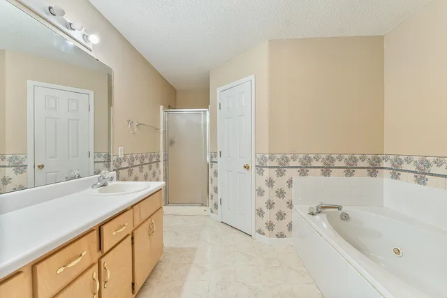 a bathroom with a tub sink and mirror