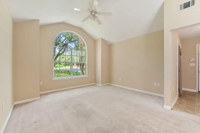 a view of a big room with windows and chandelier fan