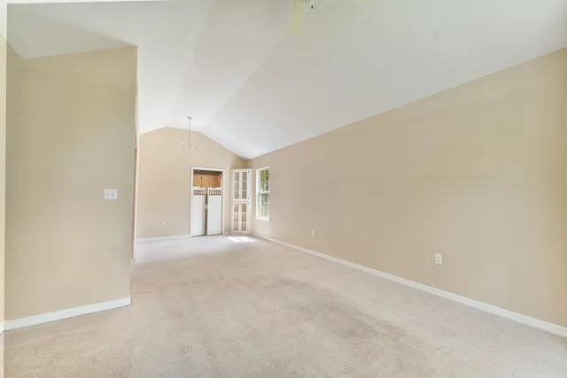 a view of a big room with windows and chandelier fan