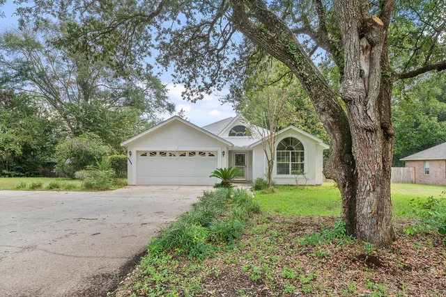a front view of a house with a yard and trees