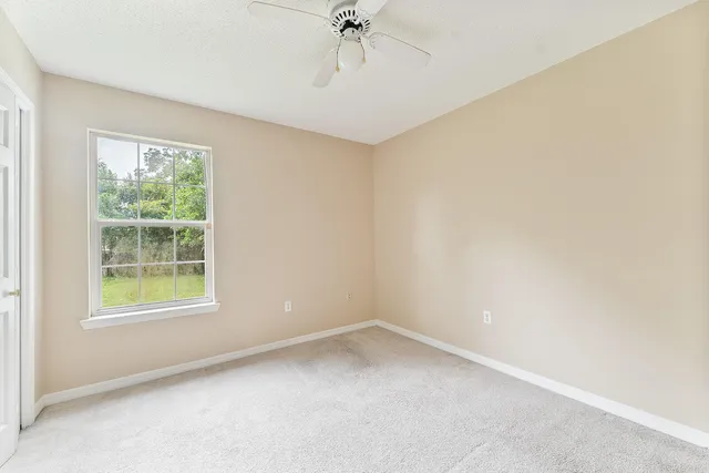 a view of an empty room with a ceiling fan