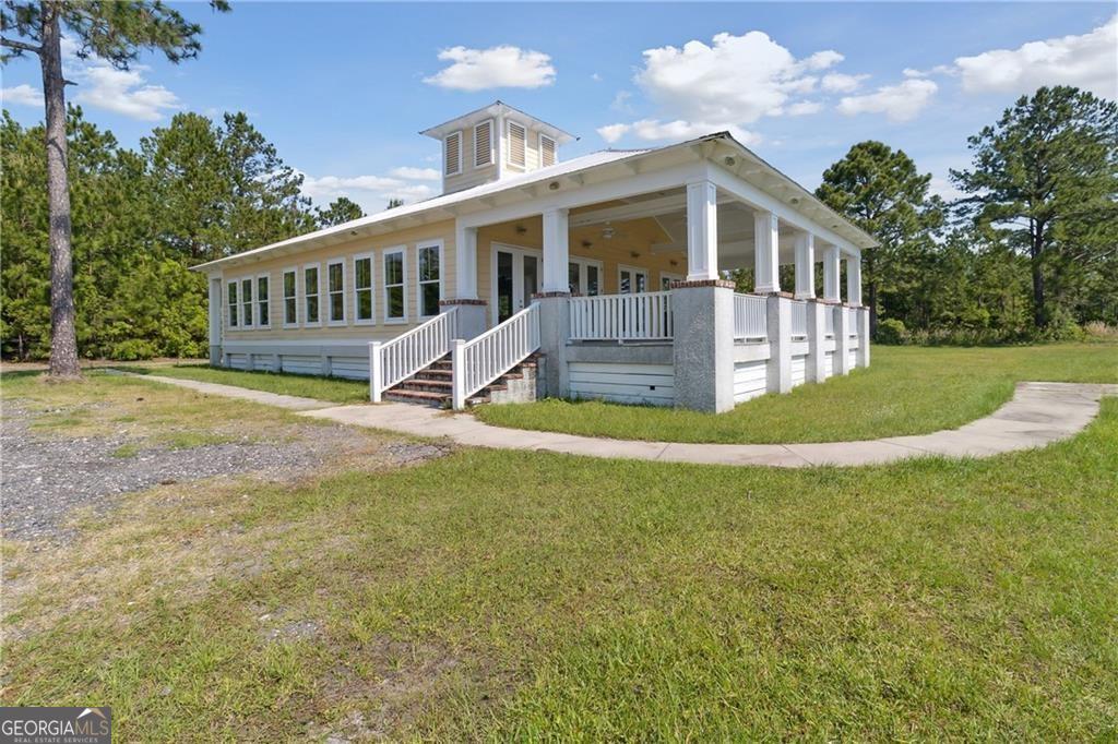 1058 Cottage Way Darien, GA 31305 - Photo 19 of 20 a front view of a house with a yard table and chairs