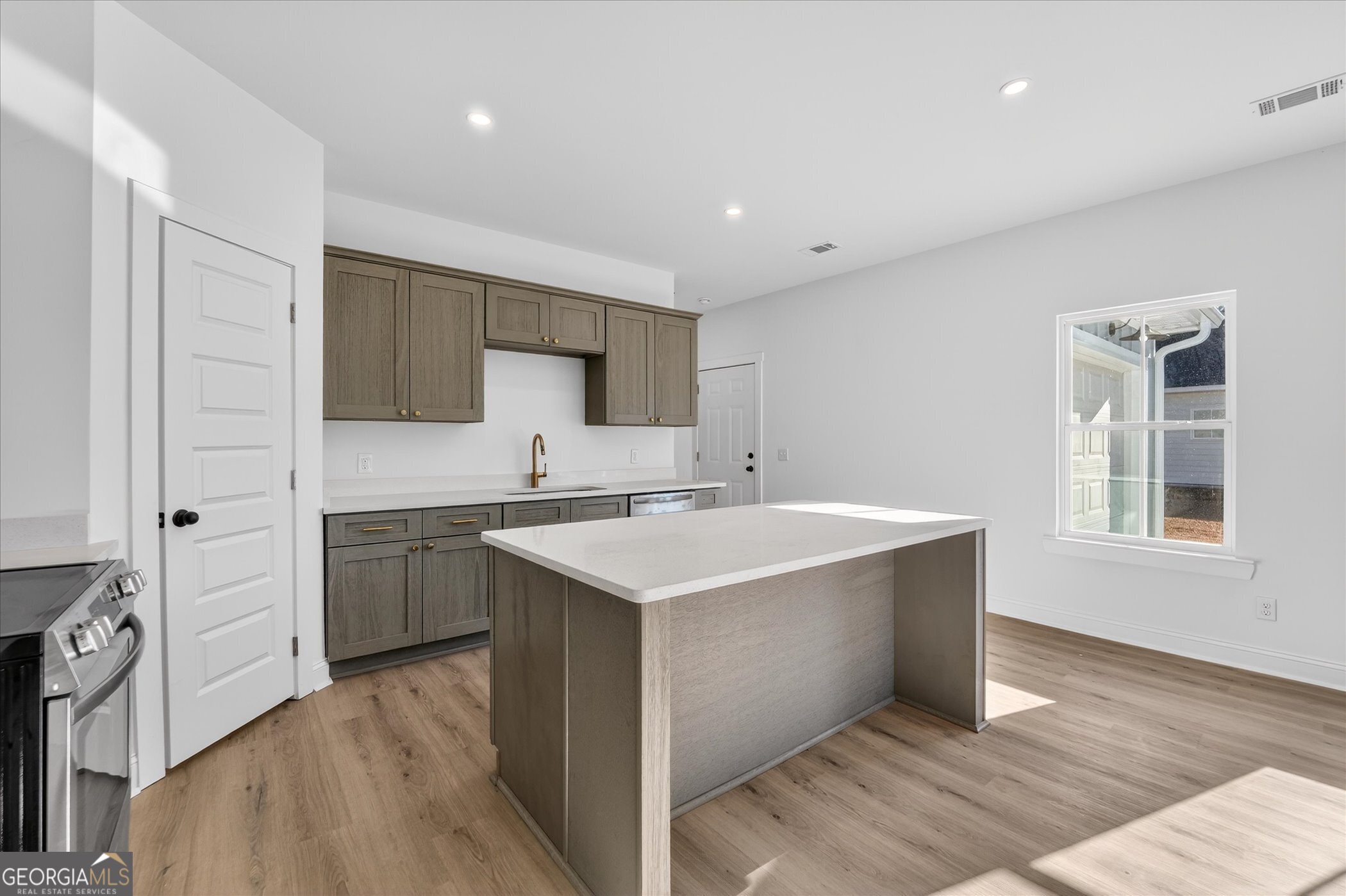 1058 Cottage Way Darien, GA 31305 - Photo 6 of 20 a kitchen with a sink stove and cabinets