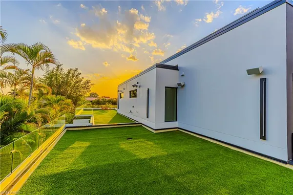 a view of an house with backyard space and balcony