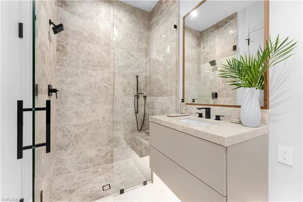 a bathroom with a sink a faucet a mirror and a shower