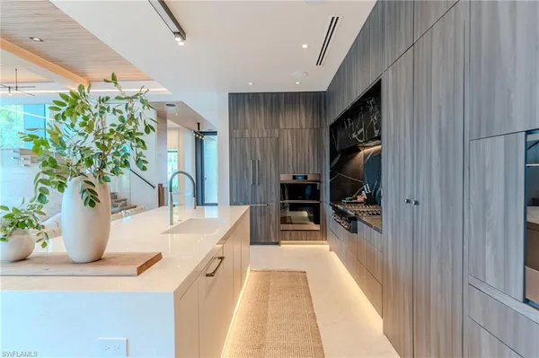 a dining hall with stainless steel appliances kitchen island granite countertop a living room view