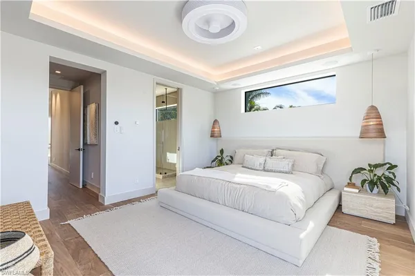 a bedroom with a bed and a potted plant