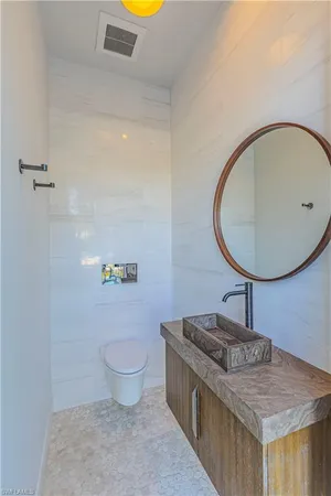 a bathroom with a granite countertop sink a toilet and a mirror