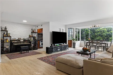 a living room with furniture and a flat screen tv with wooden floor