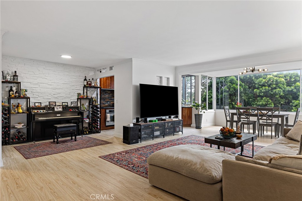 8701 Delgany Avenue, Unit 110 Playa del Rey, CA 90293 - Photo 4 of 22 a living room with furniture and a flat screen tv with wooden floor