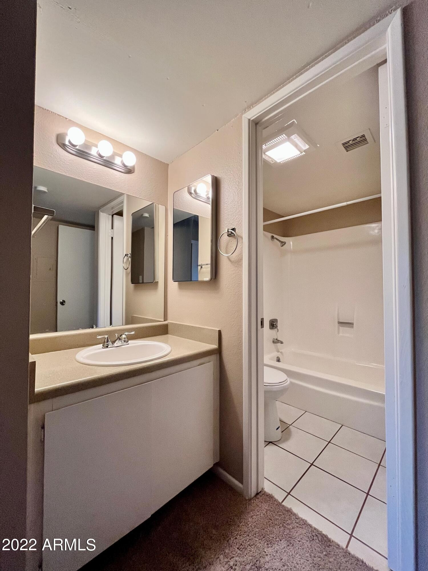 1701 West Tuckey Lane, Unit 225 Phoenix, AZ 85015 - Photo 12 of 13 a bathroom with a bathtub sink and mirror