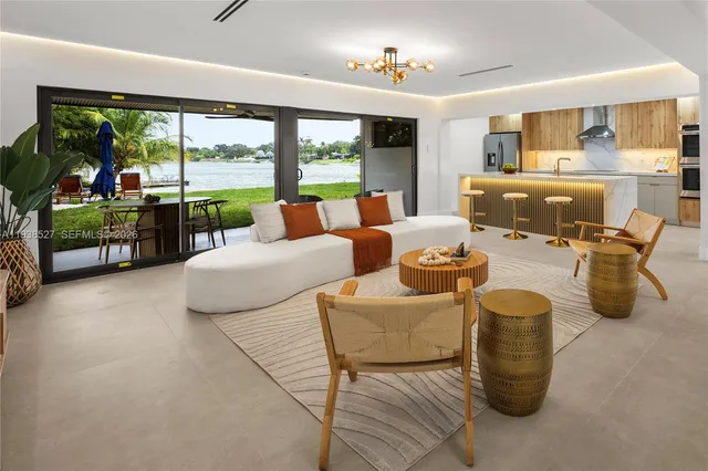 a living room with furniture large windows and flat screen tv