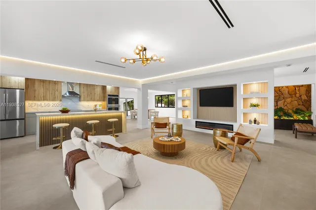 a living room with furniture kitchen view and a flat screen tv