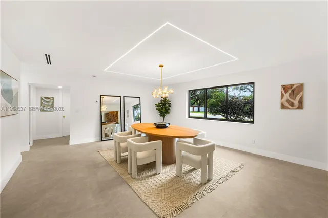 a living room with furniture a chandelier and a large window