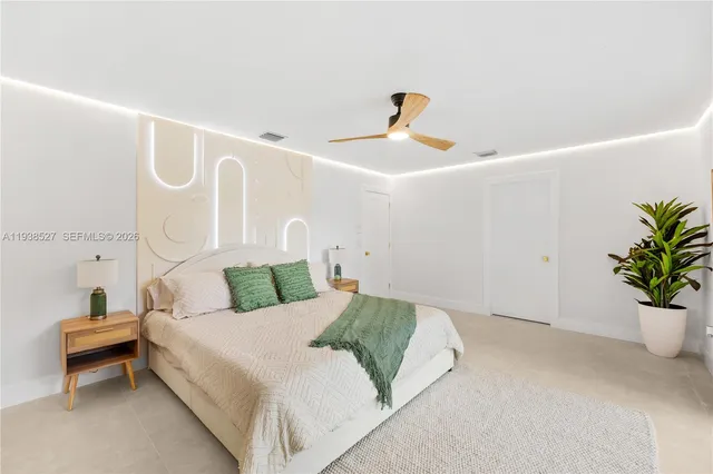 a bedroom with a bed and a potted plant