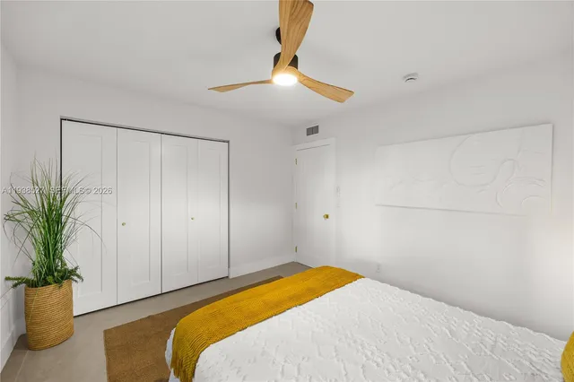 a bedroom with a bed and a potted plant