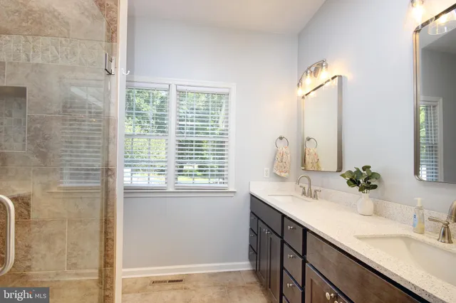 a bathroom with a double vanity sink window and a mirror