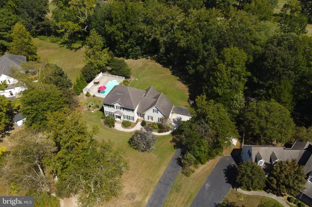 an aerial view of a house with swimming pool and outdoor seating