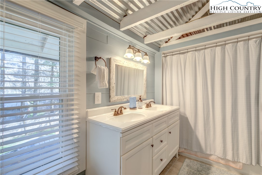 148 Fox Hill Road Vilas, NC 28692 - Photo 22 of 25 a bathroom with a double vanity sink a mirror and a shower